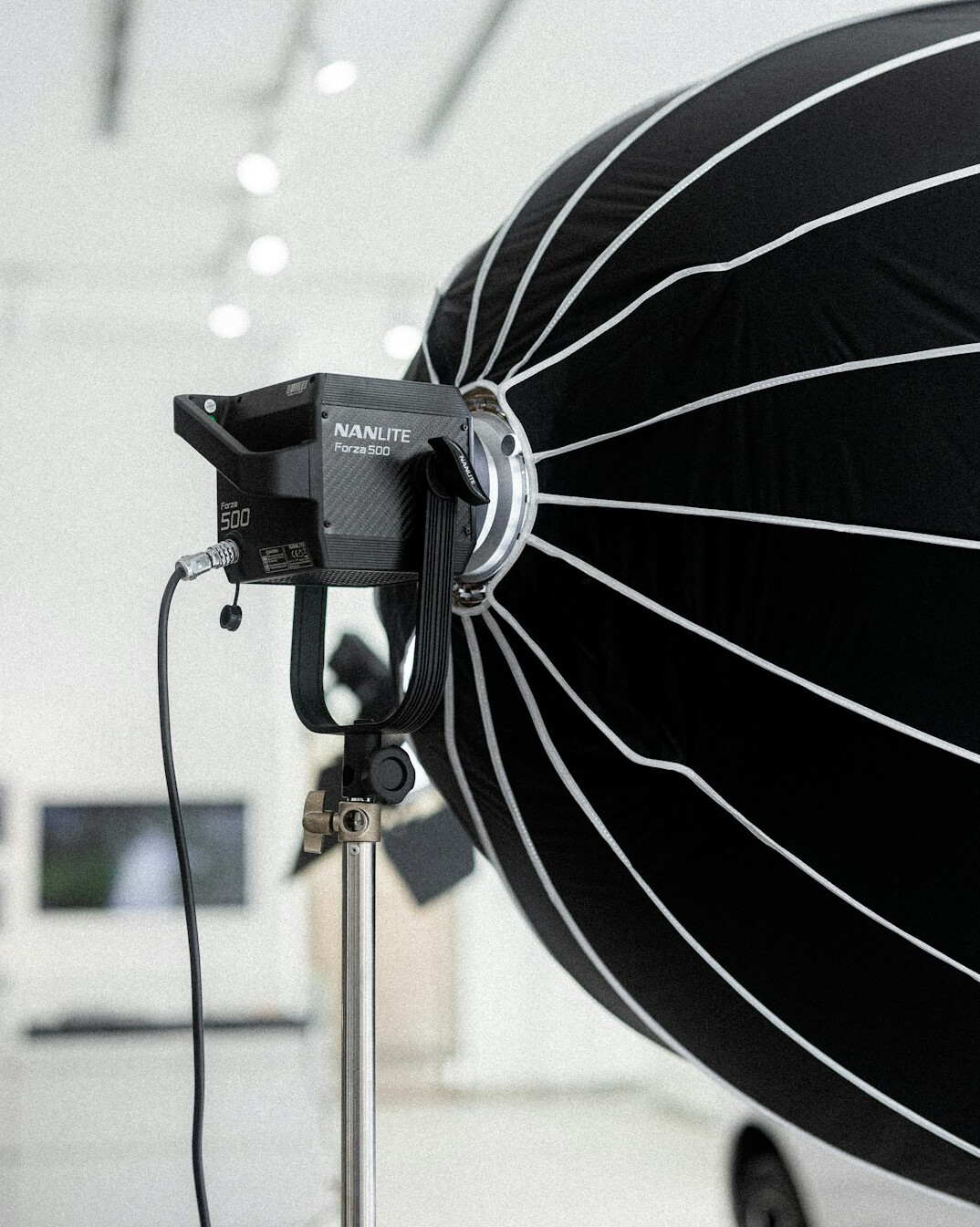 Studio lighting rig with softboxes and fresnel lights above a TV set