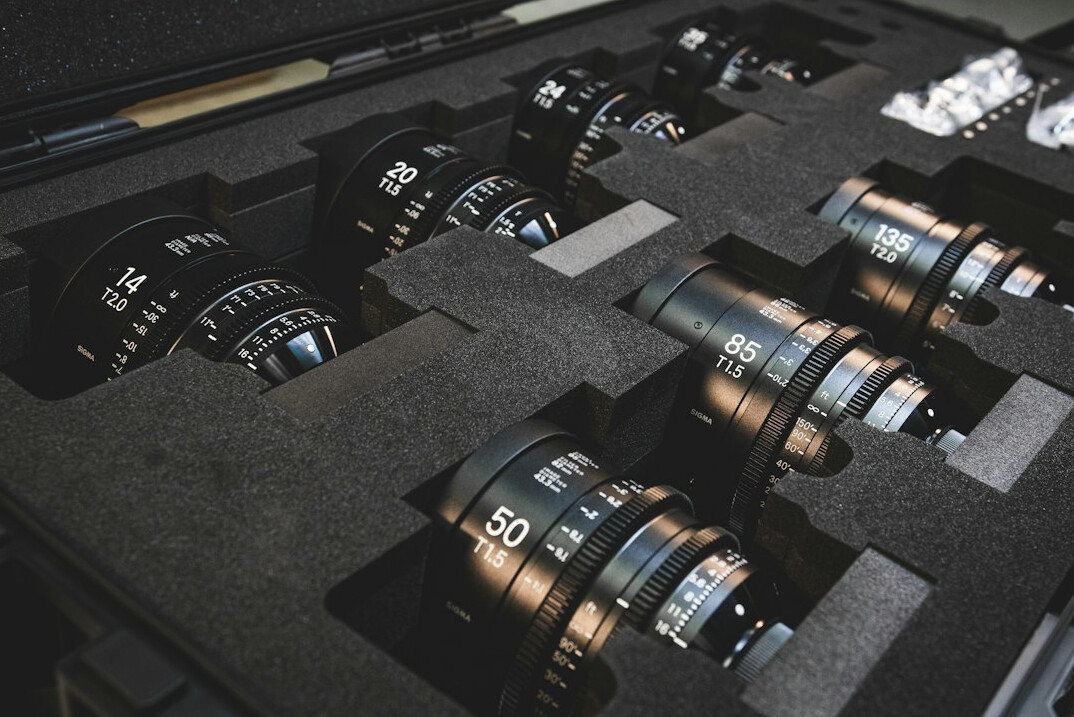 Camera lenses and broadcast gear laid out on a studio table
